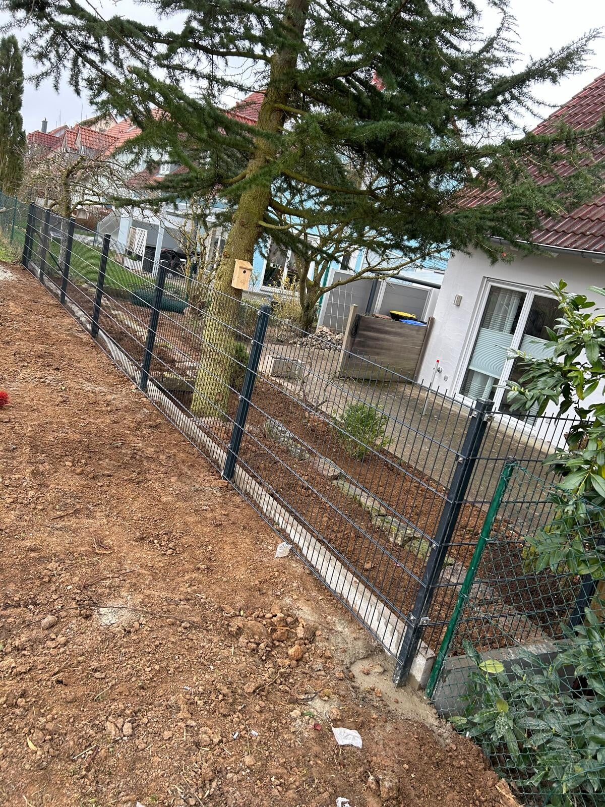 Montage eines Doppelstabmattenzauns entlang einer Grundstücksgrenze